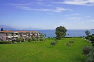 un edificio in un campo con alberi e l'oceano di Specchio sul Lago a Manerba del Garda