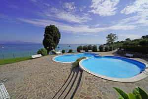 due grandi piscine sedute vicino all'acqua di Specchio sul Lago a Manerba del Garda