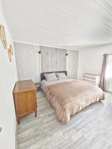 a bedroom with a large bed and a wooden table at Logis Montagnard in Modane