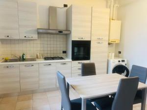 a kitchen with a wooden table and chairs at Via Brescia in Cremona
