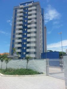 ein hohes Gebäude mit einem Zaun davor in der Unterkunft Apartamento Central in Penha