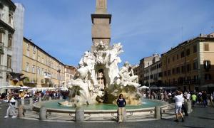 Eine Frau, die vor einem Brunnen in einer Stadt steht. in der Unterkunft Casa vacanze Little Queen in Rom