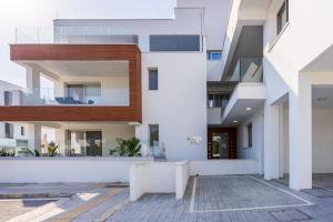 an exterior view of a building with white walls at Valleria - 2 BR Apartment W Pool in Larnaca in Larnaka