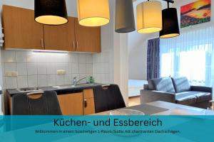 a kitchen with a sink and a table with chairs at Küstentraum Strandmuschel - 1 Raum Appartement in Binz