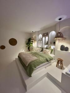 a bedroom with a bed in a white room at Bali Suite - Spa Jacuzzi in Saint Etienne