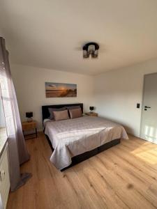 a bedroom with a large bed and a wooden floor at Charmante Schlossblick Wohnung in Aschaffenburg