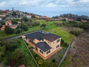 an aerial view of a house on a hill at Porto Moniz Yellow House in Porto Moniz