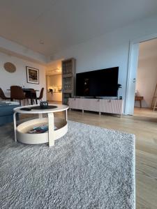 un salon avec une table et une télévision dans l'établissement The Arctic Explorer Exclusive, à Tromsø