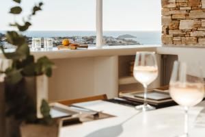 dos copas de vino en una mesa con vistas al océano en Villa Flo, en Naxos Chora