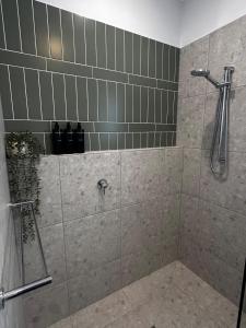 y baño con ducha y pared de azulejos. en The Wellsford Cabin - Retreat & Holiday With Your Horse, en Goornong