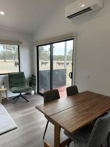 Una sala de estar con una mesa y sillas de madera. en The Wellsford Cabin - Retreat & Holiday With Your Horse, en Goornong