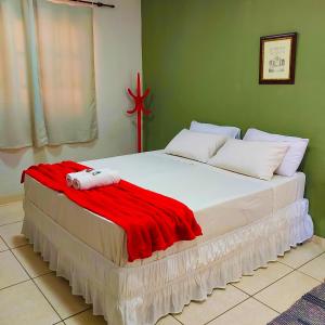 a bedroom with a bed with a red blanket on it at Pousada Pouso Alegre in Macuco +14 photos
