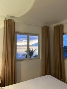 a bedroom with a bed and two windows at Salamya Guesthouse in San Juan