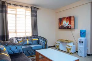 a living room with a couch and a table at MariKings place in Ruaka