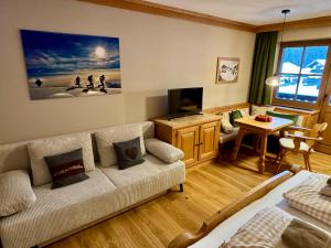 a living room with a couch and a tv at Alpennest Blindau in Reit im Winkl