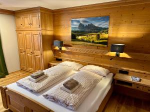 two beds in a room with wooden walls at Alpennest Blindau in Reit im Winkl