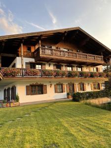 a large building with a balcony and a yard at Alpennest Blindau in Reit im Winkl