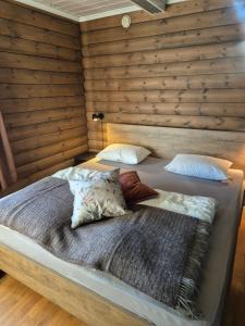 two beds in a room with a wooden wall at Geilo Hytter & Camping in Geilo