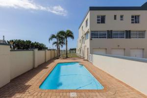 a swimming pool in front of a house at 7 Uvongo Breeze in Margate