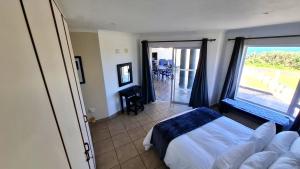 a bedroom with a bed and a view of the ocean at 7 Uvongo Breeze in Margate