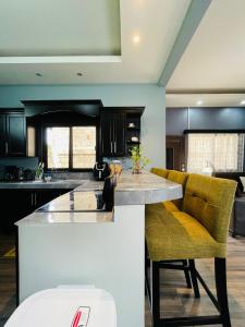 a kitchen with a counter and some yellow chairs at Duplex en Residencial Los Llanos II etapa, Catacamas in Catacamas