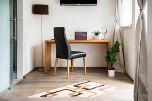 a desk with a chair and a laptop on it at Hotel Vier Jahreszeiten an der Therme & Kliniken Bad Krozingen Nähe Freiburg & Schwarzwald Ideal für Wellness Kur & Business Ausflüge 24h Check In- WLAN & Parken gratis in Bad Krozingen