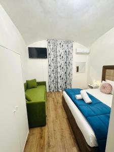 a bedroom with a bed and a green couch at Western Termini Guest House in Rome