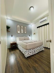a bedroom with a large bed and wooden floors at Duplex en Residencial Los Llanos II etapa, Catacamas in Catacamas +11 photos