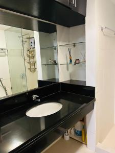 a bathroom with a sink and a mirror at The Mindful Home - 2BR Cozy Condo near NAIA in Manila