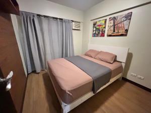 a small bedroom with a bed in front of a window at The Mindful Home - 2BR Cozy Condo near NAIA in Manila