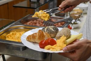 a person holding a plate of food on a buffet at Hostel Sveta Ana in Koper
