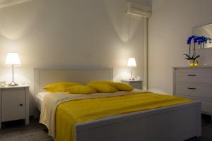 a bedroom with a bed with yellow sheets and pillows at Apartments Topli Bok in Trogir