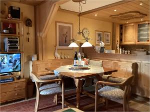 a dining room with a table and chairs and a television at Ferienwohnung Vogel in Siegsdorf