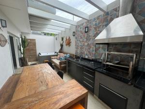 a kitchen with a wooden table and a large oven at Beautiful house Juquehy in São Sebastião