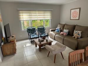 a living room with a couch and chairs and a table at Beautiful house Juquehy in São Sebastião