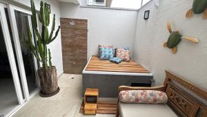 a bench in the corner of a room with a plant at Beautiful house Juquehy in São Sebastião +42 photos