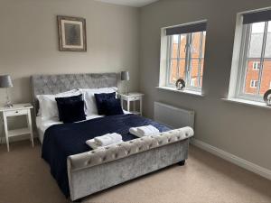 a bedroom with a bed with two towels on it at Stylish & spacious harbour-view townhouse with parking in Whitby