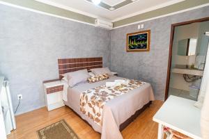 ein kleines Schlafzimmer mit einem Bett und einem Spiegel in der Unterkunft Pousada Igarapé in Socorro