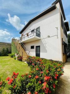 a white house with a staircase and red flowers at Duplex en Residencial Los Llanos II etapa, Catacamas in Catacamas