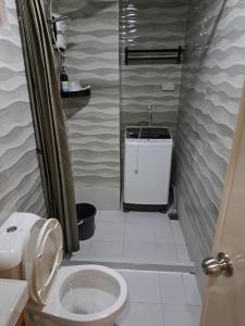un piccolo bagno con servizi igienici e doccia di C&W Royal Oceancrest Mactan a Sudtungan