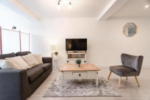 a living room with a couch and a table and a tv at Commercial Road Apartments Central Location Wyvern Theatre in Swindon