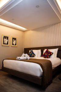 a bedroom with a large bed with colorful pillows at Zind Naaba Hotel in Lomé