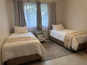 a bedroom with two beds and a window at The Aurum guesthouse in Durban +26 photos