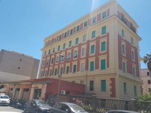 a tall building with cars parked in front of it at Odissea Apartment in Nettuno