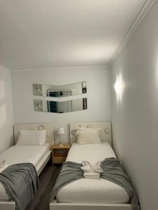 two beds in a room with white walls at Casa Estrelinha Vilamoura in Quarteira +49 photos