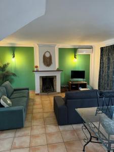 a living room with two couches and a fireplace at Casa Estrelinha Vilamoura in Quarteira