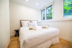 une chambre avec un grand lit blanc avec une fenêtre dans l'établissement CIA - Parc Monceau 4P, à Paris