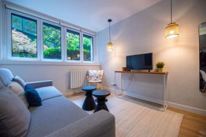 un salon avec un canapé et une télévision dans l'établissement CIA - Parc Monceau 4P, à Paris