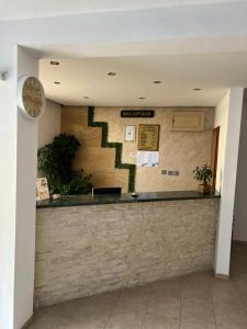 a lobby with a counter and a clock on the wall at Family Hotel Milev in Sveti Vlas +124 photos