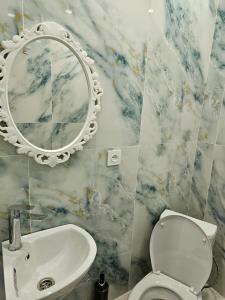 a bathroom with a toilet and a sink and a mirror at Апарт Отель MaRi in Shymkent